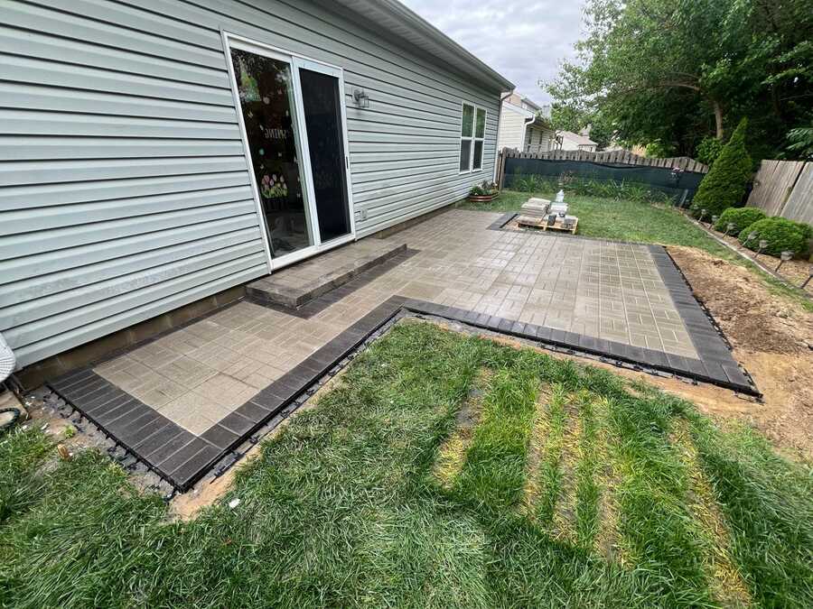 Finished paver patio with contrasting border and step to the sliding door